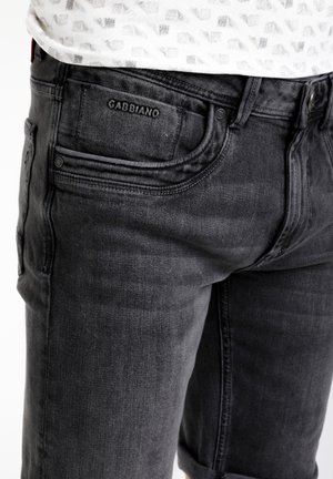 Pantalones cortos de mezclilla negra con una textura suave, que cuentan con un diseño de cinco bolsillos, dobladillos enrollados y una pequeña etiqueta de marca en el bolsillo trasero.