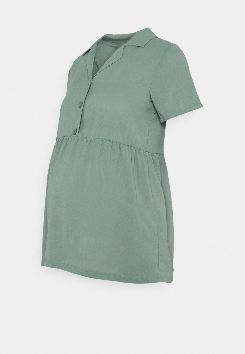 Blouse de maternité vert sauge à manches courtes avec col à boutons et taille froncée pour le confort et le style.