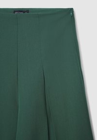 Gonna in tessuto verde, texturizzata, con zip laterale e pieghe, dal design pulito e a vita alta, del marchio Calliope.