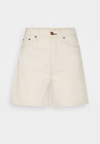 Shorts de mezclilla beige de talle alto, diseño de cinco bolsillos, cremallera frontal y detalle de parche de cuero. Textura suave con costuras resistentes.