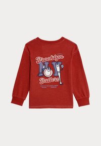 Rode longsleeve t-shirt met witte en blauwe grafische print met de tekst "Brooklyn Ballers," voorzien van honkbalmotieven en geribbelde cuffs.