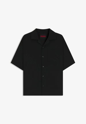 Lyhythihainen musta napitettava paita, jossa on kaulus ja tasku. Valmistettu sileästä kankaasta, jossa on hieno kiilto, ja etuosassa on viisi mustaa nappia.