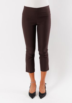 Pantaloni cropped marroni attillati con una texture liscia, dotati di una vita a media altezza e orlo pulito. Abbinati a tacchi alti neri a punta.