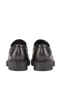 Schwarze Lederschuhe mit glatter Oberfläche, runder Zehenpartie und niedrigem Gummisohle. Mit genähten Akzenten an der Ferse und der Seite.