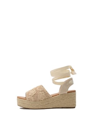 Sandalias de cuña beige con una tira delantera bordada, suela de esparto texturizada y lazos de tela entrecruzados en el tobillo.