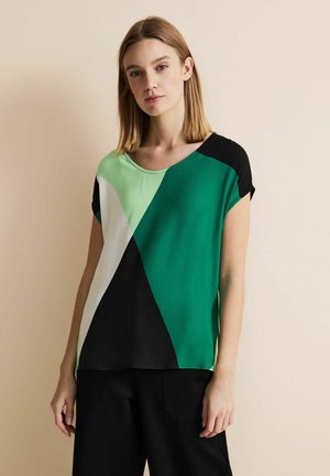Kurzarmbluse mit asymmetrischem Design in Grün, Schwarz und Weiß. Glattes Material mit Rundhalsausschnitt und lockerer Passform.