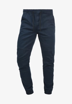 Navy blue jogger pants made of cotton blend, featuring an elastic waistband with drawstring, ribbed cuffs, and subtle seam detailing.