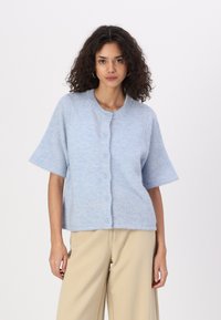 Cardigan bleu clair à manches courtes en matière douce et duveteuse. Il présente un col rond et une fermeture à boutons sur le devant.