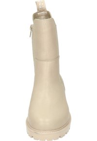Botín de cuero beige hasta el tobillo con una superficie texturizada, punta redonda y una suela clara en contraste. Presenta una cremallera en la parte trasera y una tira de agarre.
