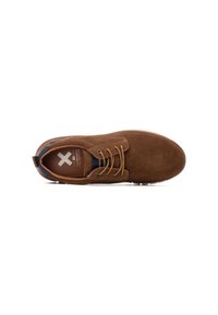 Zapato marrón de ante con cordones, punta redondeada, cordones color beige, plantilla con marca y suela de goma blanca; presenta una lengüeta en la parte posterior para facilitar el calzado.