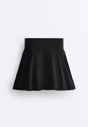 Jupe évasée noire taille haute avec large ceinture, tissu lisse et plis légers, présentée sur fond blanc uni.
