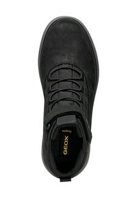 Zapatilla de cuero negro con textura suave, punta redonda, diseño de cordones y tira de velcro con una etiqueta de logo dorado en la lengüeta.