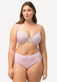 Vaaleanpunainen rintaliivi, jossa on tasoittavat kupit ja säädettävät olkaimet; yhteensopivat korkeat alushousut, joissa on pitsikoristeet sivuilla ja nauhakiinnitys.