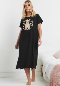 Vestito da notte nero con grafica di un cane e la scritta "stay pawsitive". Maniche corte, vestibilità comoda, tessuto morbido, design fino al ginocchio.
