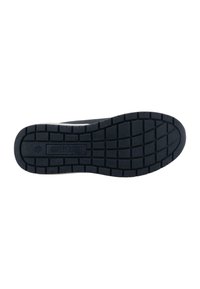Semelle de chaussure en caoutchouc noir avec un motif de traction, comportant un logo au centre. Le design est plat et légèrement courbé sur les bords.