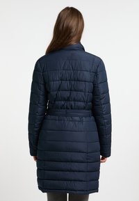 Geacă puffer bleumarin cu talie accentuată, având un design matlasat și un guler înalt. Textura netedă și croiala de lungime medie pentru căldură.
