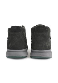 Bottes chelsea en daim gris foncé avec une texture lisse, dotées d'un col rembourré, d'une semelle en caoutchouc grise et de détails de design minimalistes.