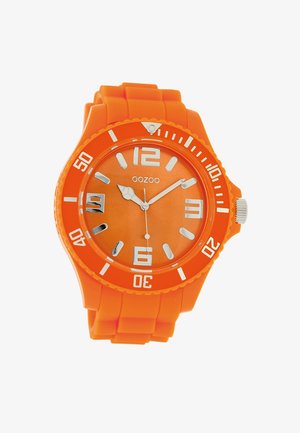 Montre en silicone orange avec un cadran rond, des repères numériques blancs et des aiguilles argentées. Elle possède des repères horaires audacieux et une lunette texturée.