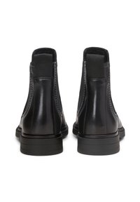 Stivaletti alla caviglia in pelle nera con pannelli elastici laterali, texture liscia, punta rotonda e suola in gomma bassa e strutturata.