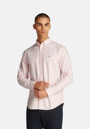 Camisa de botón de color rosa claro con finas rayas blancas, cuello casual y pequeño logo en el pecho; hecha de una tela suave.