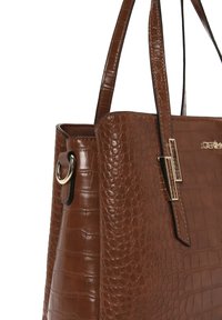 Borsa a mano in finta pelle marrone con motivo a coccodrillo, dotata di accessori in oro e una forma strutturata. Due manici attaccati con anelli.