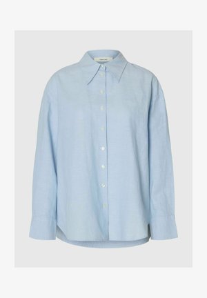 Lyseblå langermet skjorte med knapper, vid og spiss krage og mansjetter med én knapp, vist mot nøytral bakgrunn.