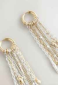 Zlate obročeve uhane z padajočimi verigami iz izmeničnih zlatih in srebrnih povezav, okrašene s prozornimi kristali in dekorativnimi poudarki.