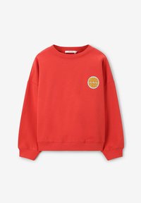 Sweatshirt rouge à col rond et épaules baissées, avec un graphique circulaire "Good Vibes" en jaune. Fabriqué en tissu en coton doux.