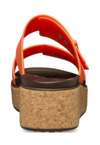 Sandales plateforme en liège avec des brides synthétiques orange vif, présentant une forme arrondie, un fond de semelle texturé et une base brune contrastante.
