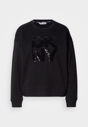 Fekete pulóver, középen texturált, flitteres "DKNY" logóval. A dizájn kerek nyakkivágást és bordázott mandzsettákat tartalmaz. Puha anyagból készült.