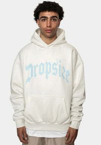 Hvit hettegenser laget av mykt stoff, med stor blå grafisk tekst "Dropsize" på forsiden, med kengurulomme og elastiske mansjetter.