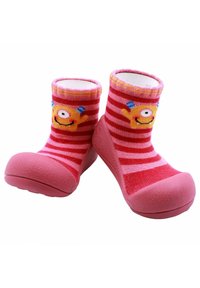 Calcetines para bebés de rayas rosas y rojas con una parte superior de tela suave y fondo de goma, que presentan un diseño de un monstruo sonriente en la parte frontal.