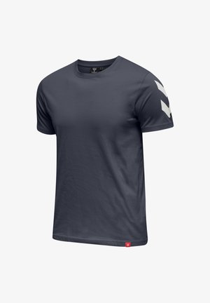 Kortärmad t-shirt med rund hals i mörk marinblått tyg. Har ett vitt chevronmönster på vänster axel och en liten röd logotyp längst ner till vänster.