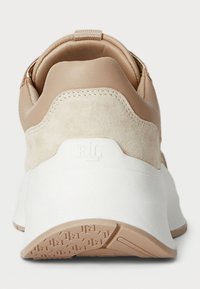 Basket beige en suède et cuir lisse avec une semelle blanche, dotée d'une semelle extérieure en caoutchouc texturé et d'un tirant au talon pour un enfilage facile.