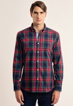 Camisa de manga larga de cuadros en colores navy, rojo y azul, con cuello abotonado y botones blancos, fabricada en material de algodón.