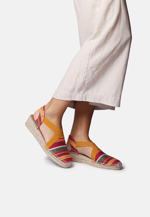 Barvite espadrile sandale z večbarvnim črtastim tekstilnim zgornjim delom in rumenimi elastičnimi trakovi, z pletenim podplatom iz jute.