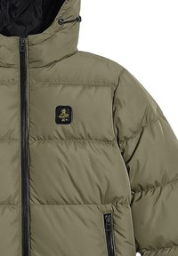 Giacca puffer verde oliva con colletto alto, chiusura frontale con zip, tasche laterali e un patch con logo nero sul petto. Texture liscia e imbottita.