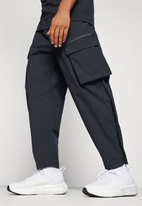 Under Armour UNSTOPPABLE - Hlače za otvoreno - black