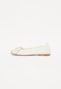 Chaussure plate blanche en matériau lisse, présentant un grand nœud sur le bout, une silhouette ronde et un petit talon en bois.