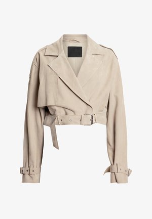 Veste en suède beige coupée avec de larges revers, épaulettes, ceinture à boucle argentée et poignets ajustables. Texture lisse et design minimal.