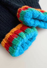 Dziergane rękawice w ciemnonawowym kolorze z wielokolorowymi ściągaczami w odcieniach niebieskiego, zielonego, czerwonego i pomarańczowego. Widoczne detale teksturowanej, przytulnej tkaniny.