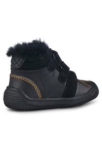 Chaussures noires et grises avec une finition texturée, dotées d'un col en fourrure douce, de bandes Velcro et de coutures jaunes contrastantes. Semelle en caoutchouc.