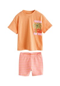 Narancssárga pamut póló rövid ujjakkal és "HAVANA FUN TIME" felirattal, rózsaszín rövidnadrággal, amely hullámos pasztellszínes csíkokat tartalmaz.