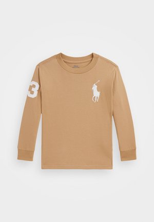 Camiseta de manga larga color beige hecha de algodón suave, con un logo de polo blanco en el pecho y un "3" blanco en la manga izquierda.