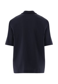 Marineblaues Poloshirt aus strukturiertem Stoff, mit klassischem Kragen und kurzen Ärmeln. Der Rücken ist schlicht mit einer dezenten Naht. 