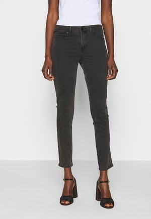 Zwarte skinny jeans van een katoenmix, met een klassieke vijf-pocketontwerp en een middelhoge taille, gecombineerd met zwarte hoge hakken sandalen.