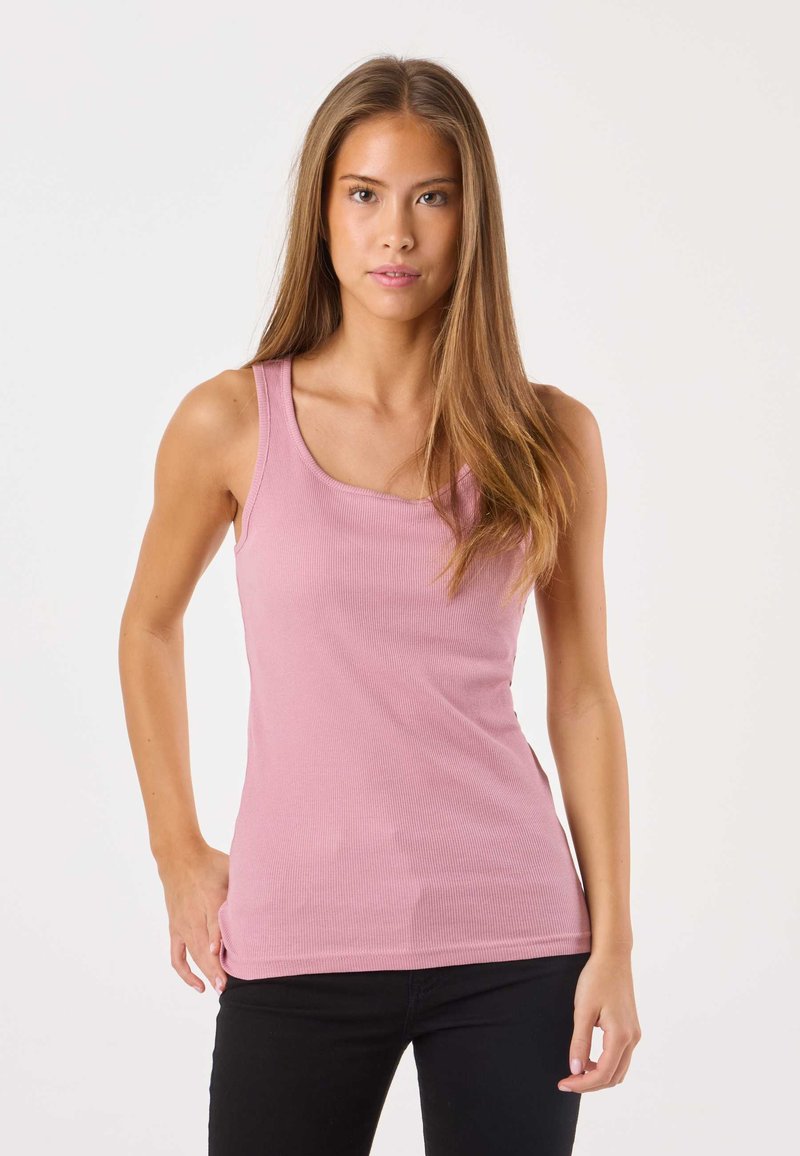 Roze geribbelde tanktop met een ronde halslijn en brede schouderbanden, gecombineerd met zwarte jeans, tegen een effen witte achtergrond.