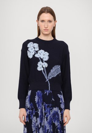 Pulover în nuanță de marină cu broderie florală în tonuri deschise de albastru, design scurt, cu manșete și tiv texturat. Modelul este asortat cu o fustă plisată florală.
