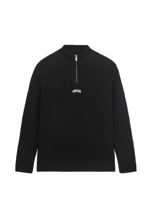 Schwarzer gestrickter Pullover mit hohem Kragen und einem Viertelreißverschluss vorne. Auf der Brust ist das Wort "UNFAIR" in Weiß gestickt.