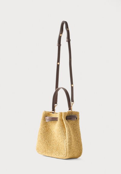 Πλεκτή τσάντα ταμπά με σκούρο καφέ δερμάτινη χειρολαβή και ρυθμιζόμενο ιμάντα ώμου με μεταλλικά στοιχεία σε χρυσαφί χρώμα.